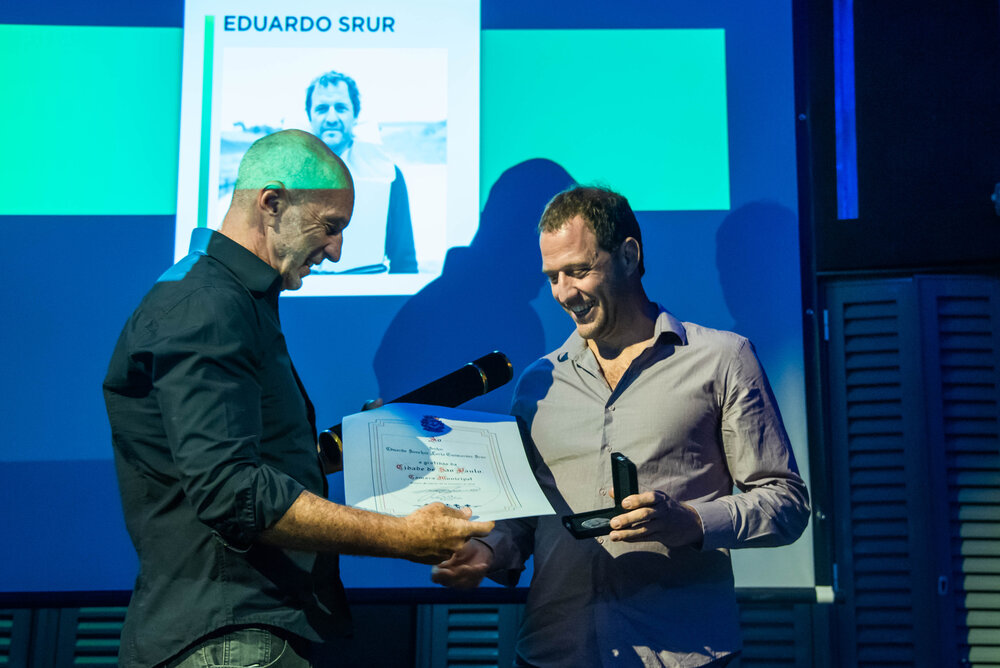 Xexéu Tripoli entrega a Medalha Anchieta e o Diploma de Gratidão ao artista Eduardo Srur.